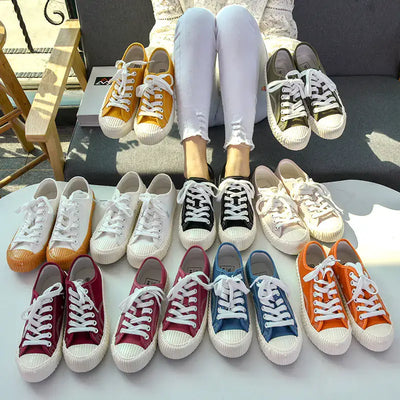 A variety of colorful mens-and-womens-canvas-sneakers displayed on a table, showcasing unisex designs in different styles.