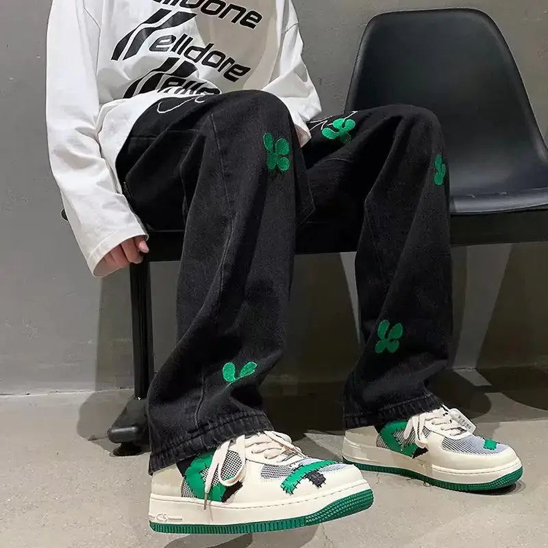 Embroidered High Street Jeans for Men worn with stylish shoes, showcasing unique embroidery in green.