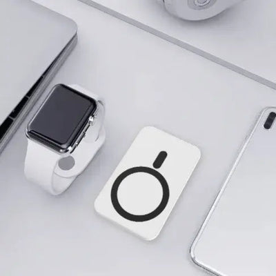 Wireless Power Bank 5000mAh placed next to a smartwatch and other devices on a desk.