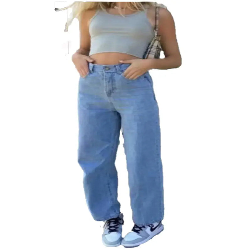 Woman wearing high-rise wide-leg jeans with a crop top and sneakers, showcasing a stylish casual outfit.