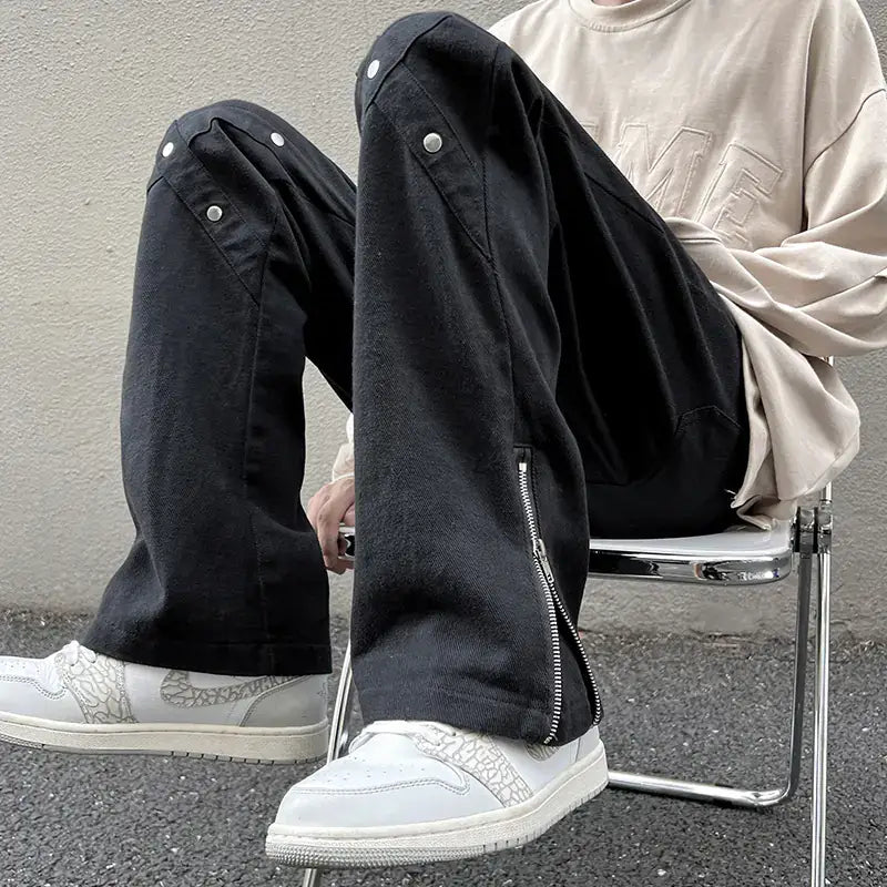 Zipper men Jeans by TideGangster worn by a man sitting in a chair, showcasing sleek zipper details and a modern style.