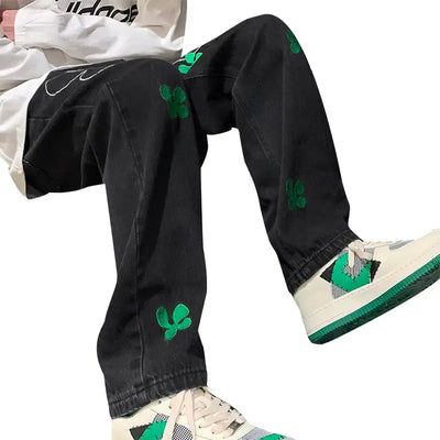 Embroidered High Street Jeans for Men with green floral designs, styled with casual sneakers and a trendy shirt.